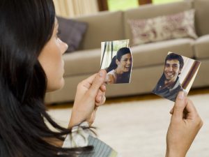 Woman with torn photograph of couple